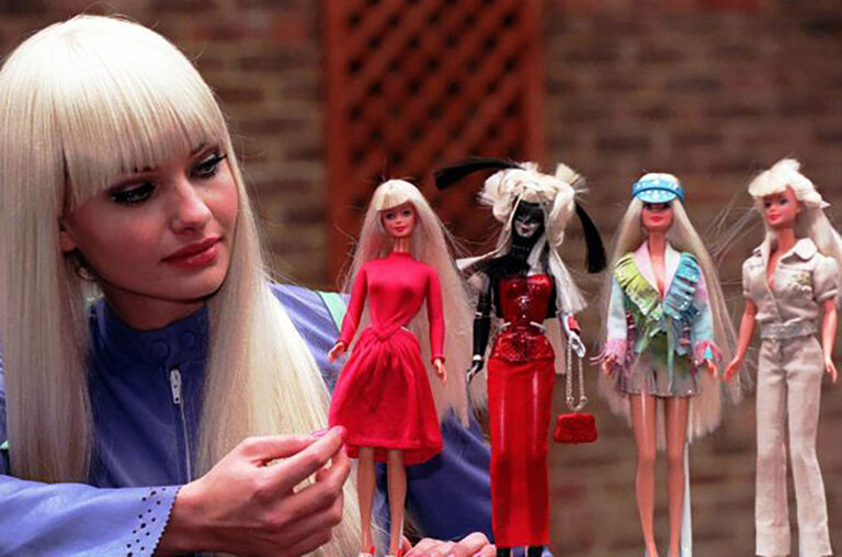 Model with several Barbie dolls for The Art of Barbie for Mattel